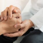 Psicóloga sosteniendo las manos de su paciente