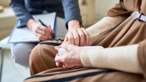 Psicóloga sosteniendo las manos de su paciente